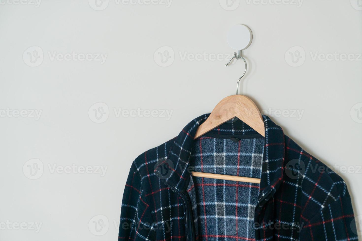 black jacket hanging with wood hanger photo