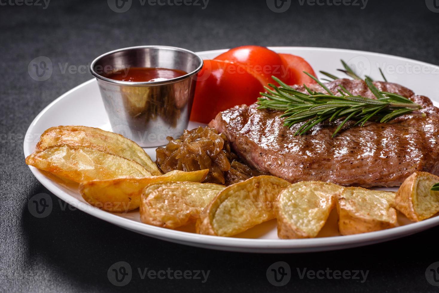 Delicious juicy beef steak with baked potatoes and sauces on a white dish photo