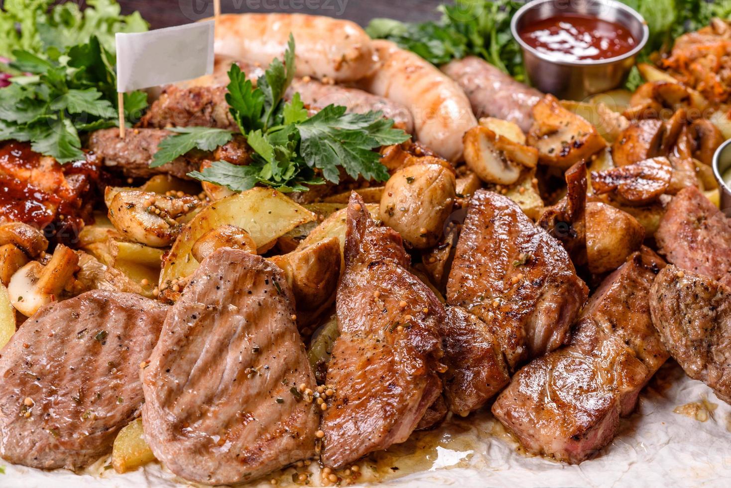 Several types of roasted meat with spices and herbs on a wooden tray photo