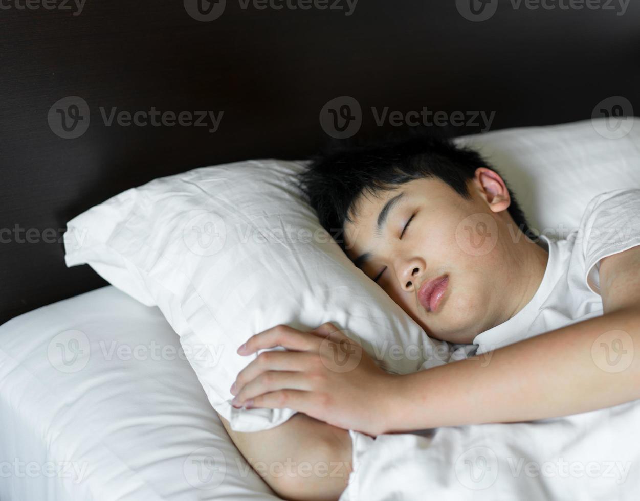 un niño duerme en la cama en el dormitorio. relax y concepto saludable foto