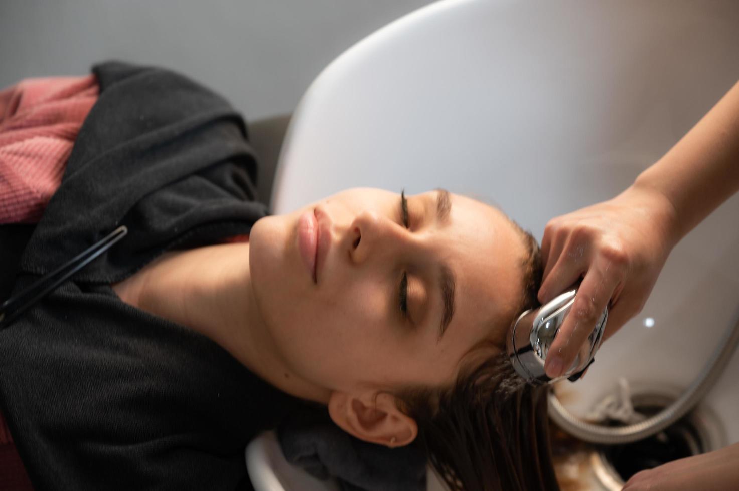woman client person having a process to making treatment a hair with hairdresser in beauty salon photo