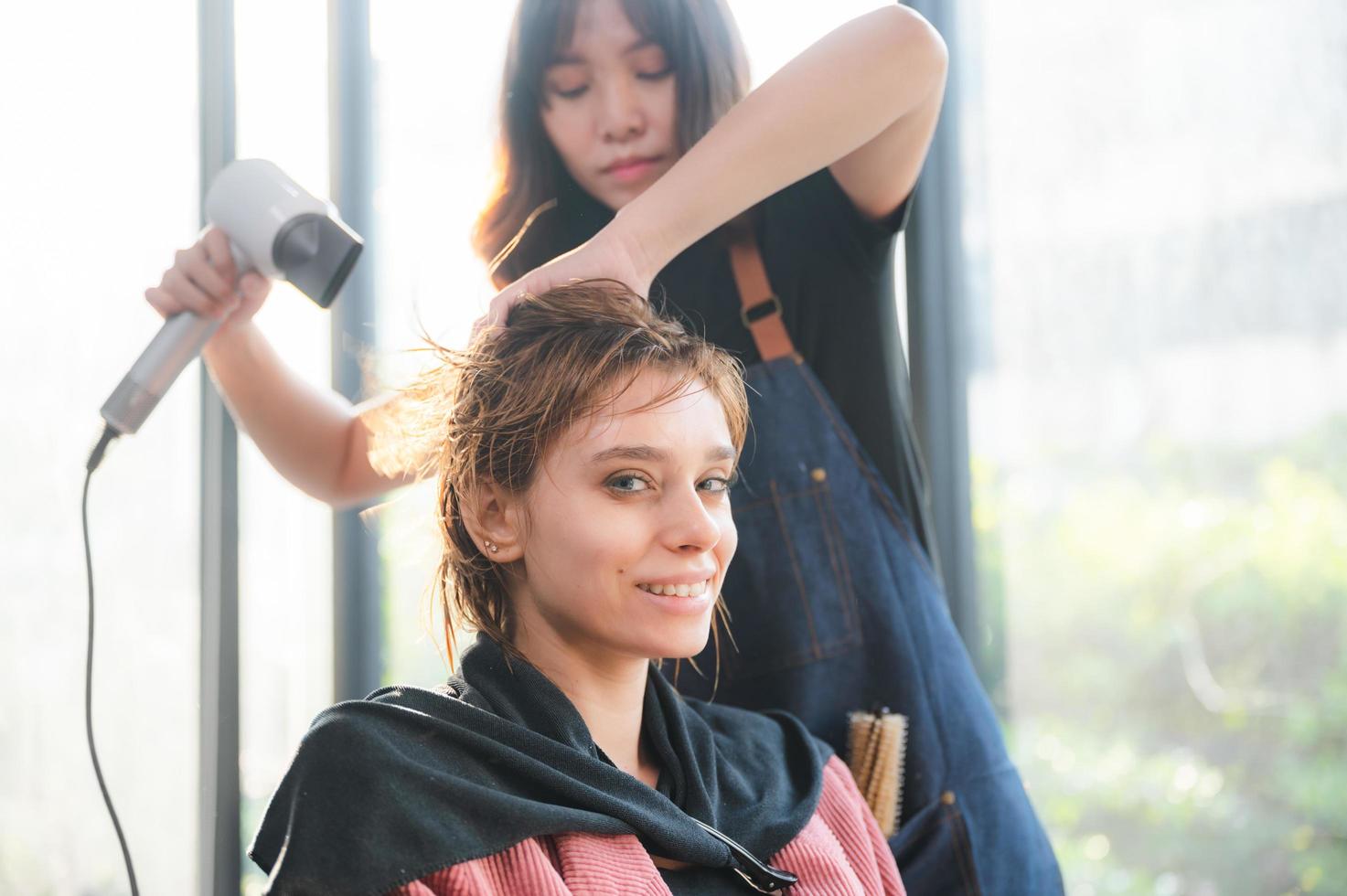 woman client person having a process to making treatment a hair with hairdresser in beauty salon photo