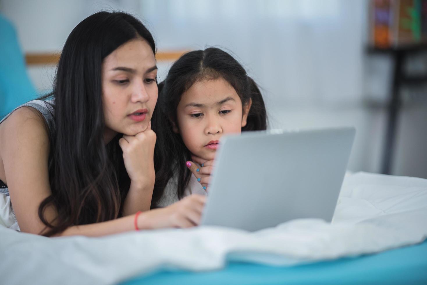 mother teaching child girl for doing homework at home, family education activity concept photo