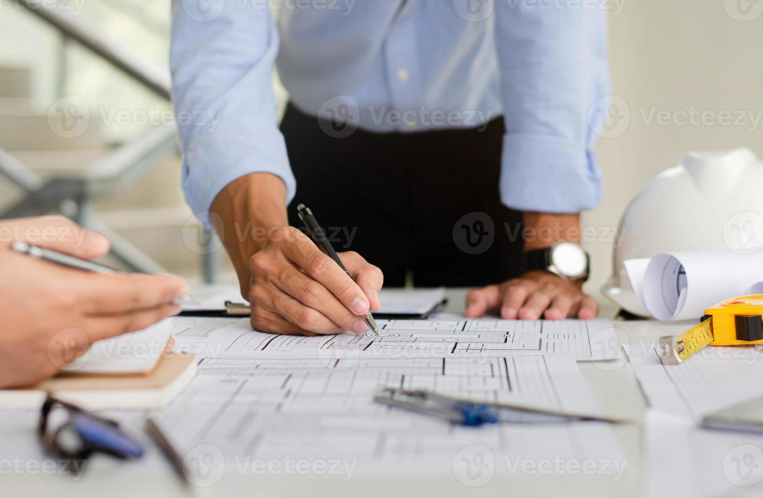 Engineer who is planning a draft of the structure. With architect equipment and team discussions about architectural blueprints at desks in modern offices. photo