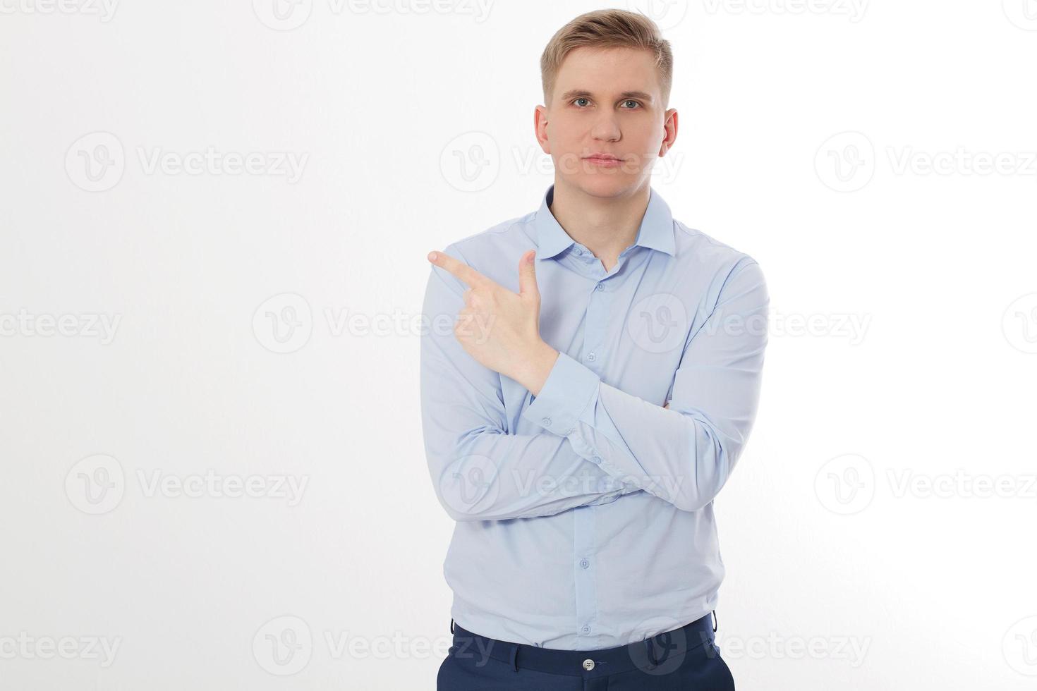 Young businessman pointing on copy space isolated on white background. Business success ceo concept. Man crossed arms. Guy leader photo