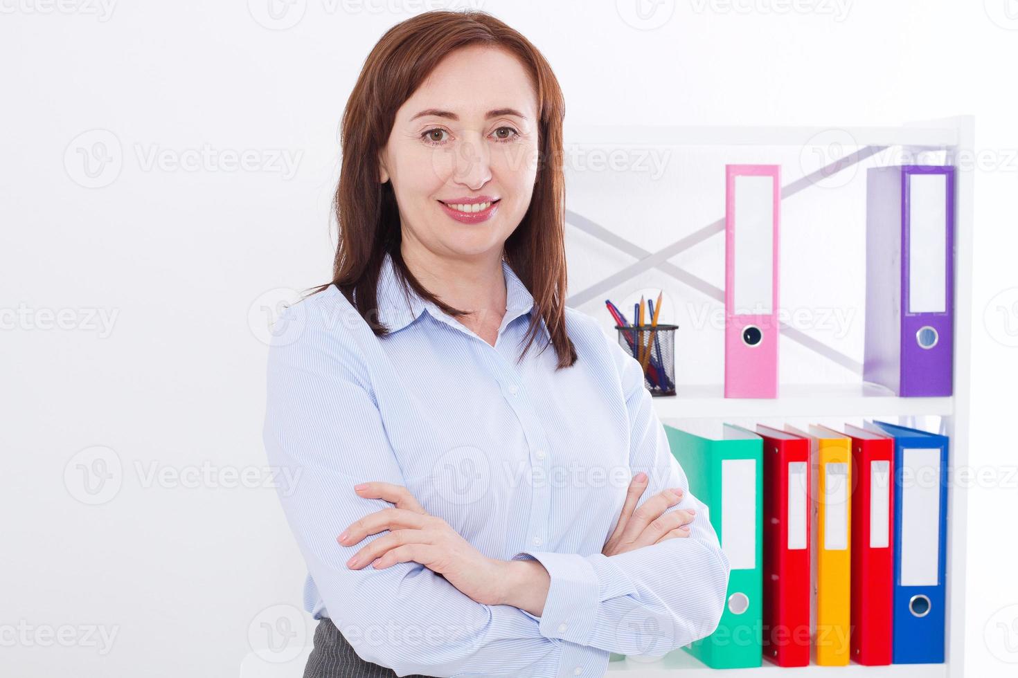 Portrait of smiling attractive businesswoman at office background isolated on white. Copy space and mock up. Selective focus photo