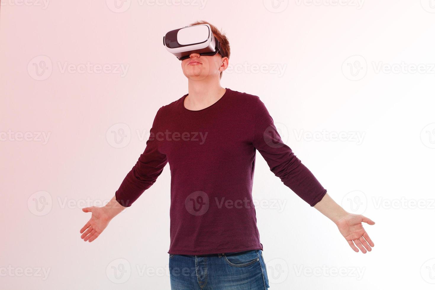 Young man wearing virtual reality goggles isolated on white background. Digital VR glasses for 360 game. Template and blank shirt. Copy space and mock up photo