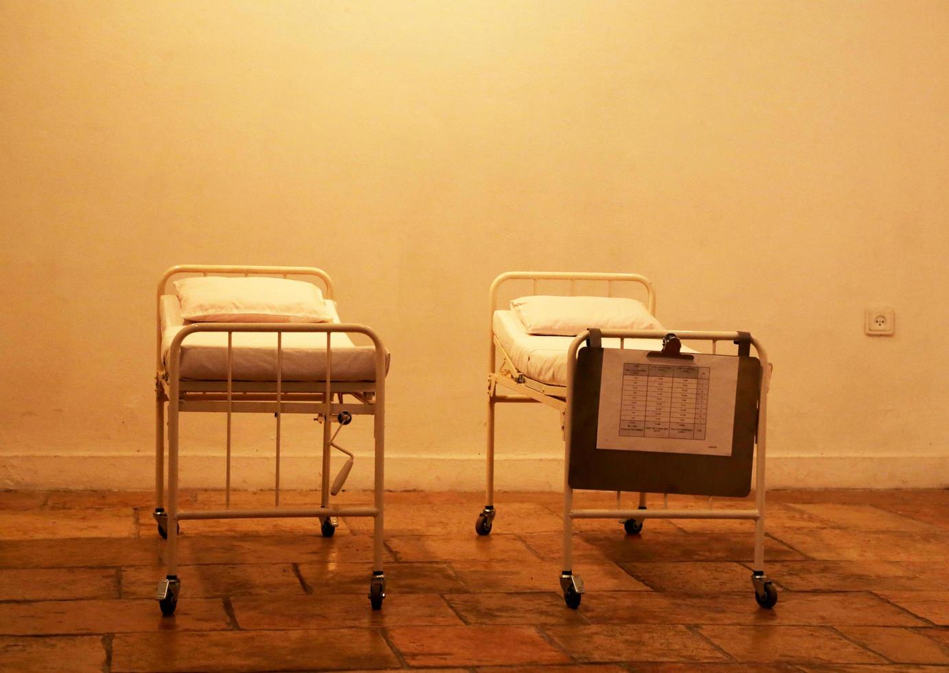 Empty hospital beds standing in abandoned room for patients photo