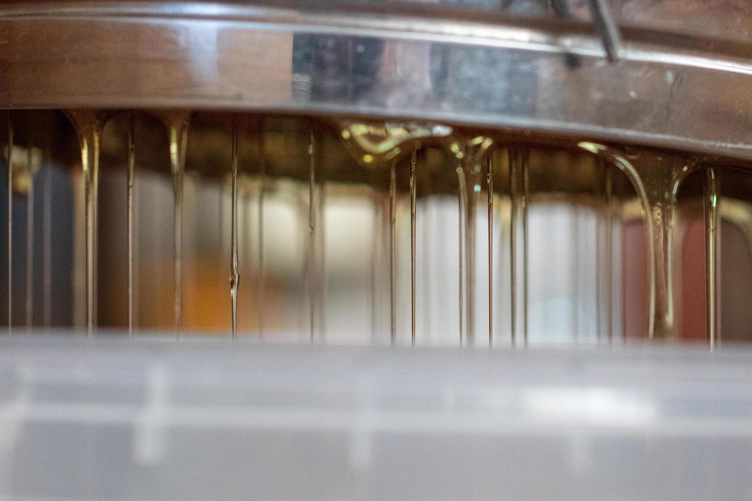 Drop of bee honey drip from hexagonal honeycombs photo
