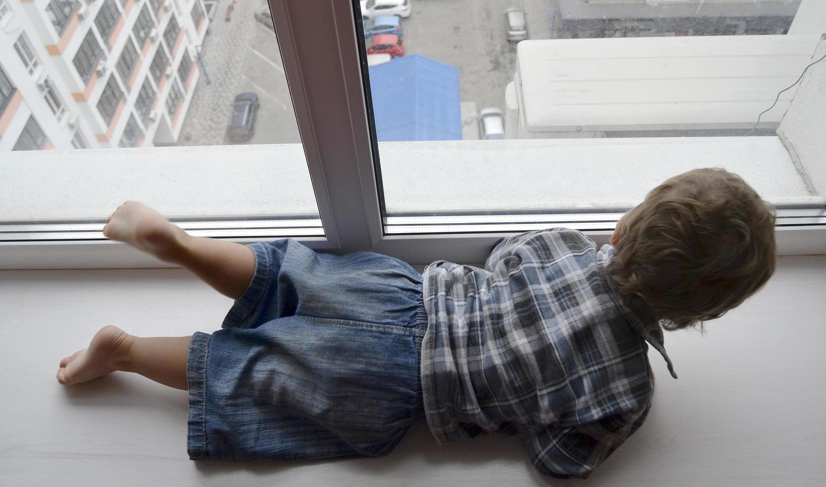 Beautiful baby boy with child face posing photographer near window photo