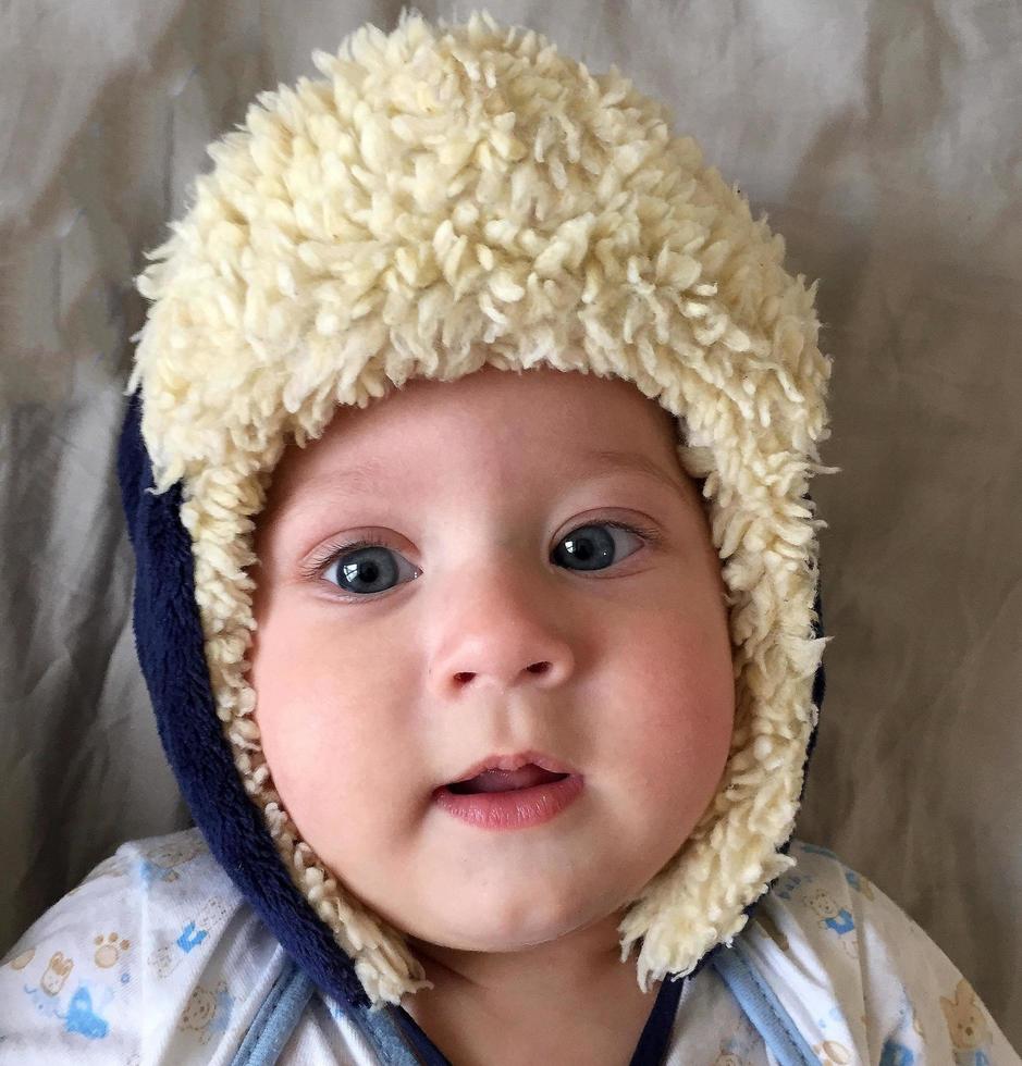 Beautiful baby boy with child hat posing photographer for color photo