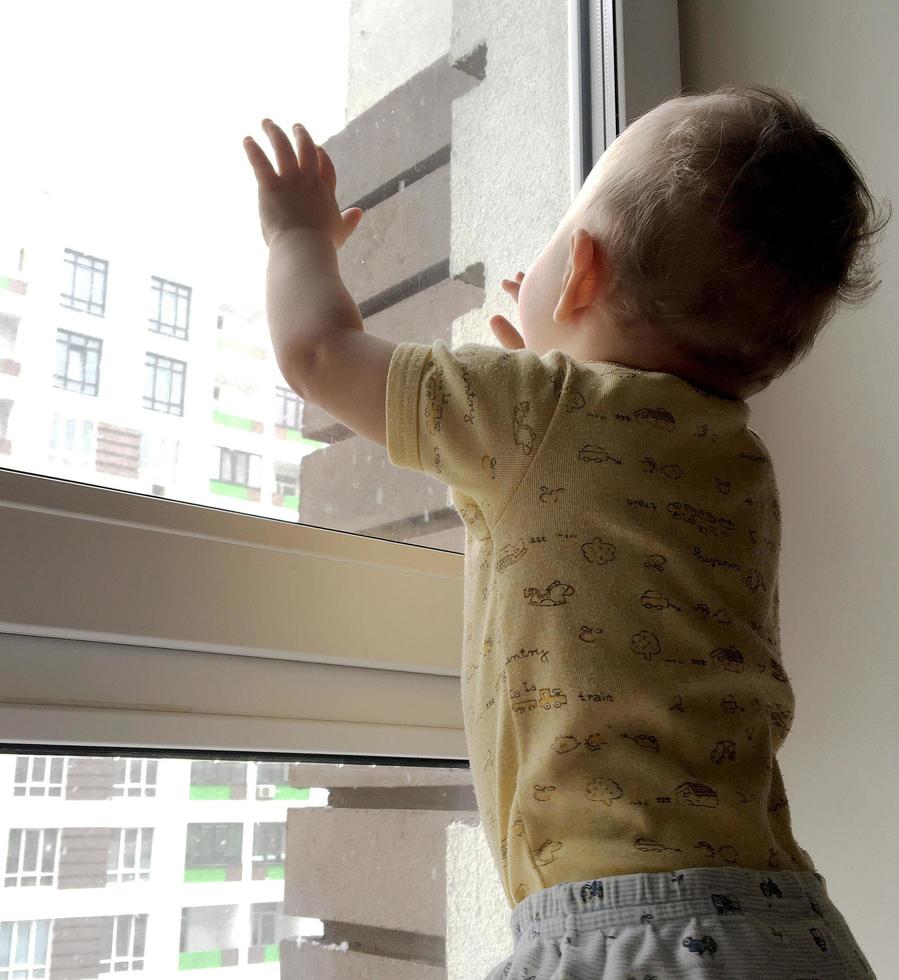 Beautiful baby boy with child face posing photographer near window photo