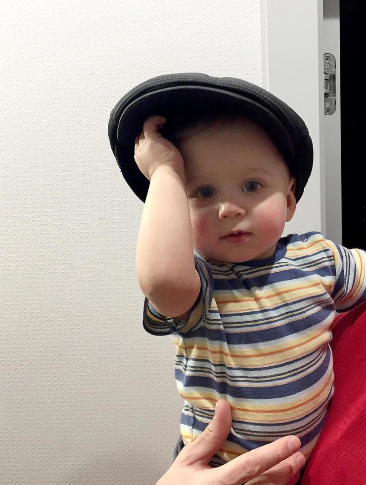 Beautiful baby boy with child hat posing photographer for color photo