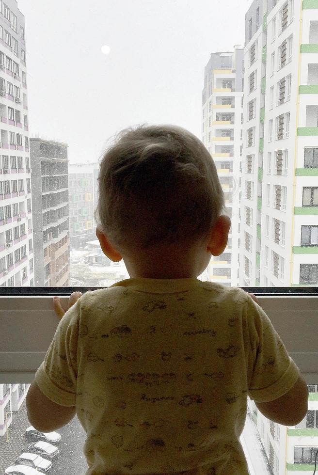 Beautiful baby boy with child face posing photographer near window photo