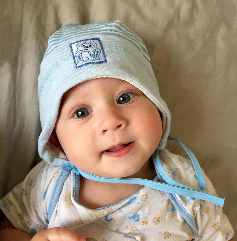 Beautiful baby boy with child hat posing photographer for color photo