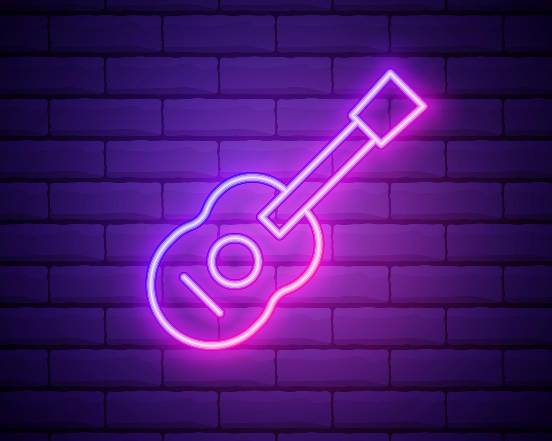 Glowing neon line Guitar icon isolated on brick wall background