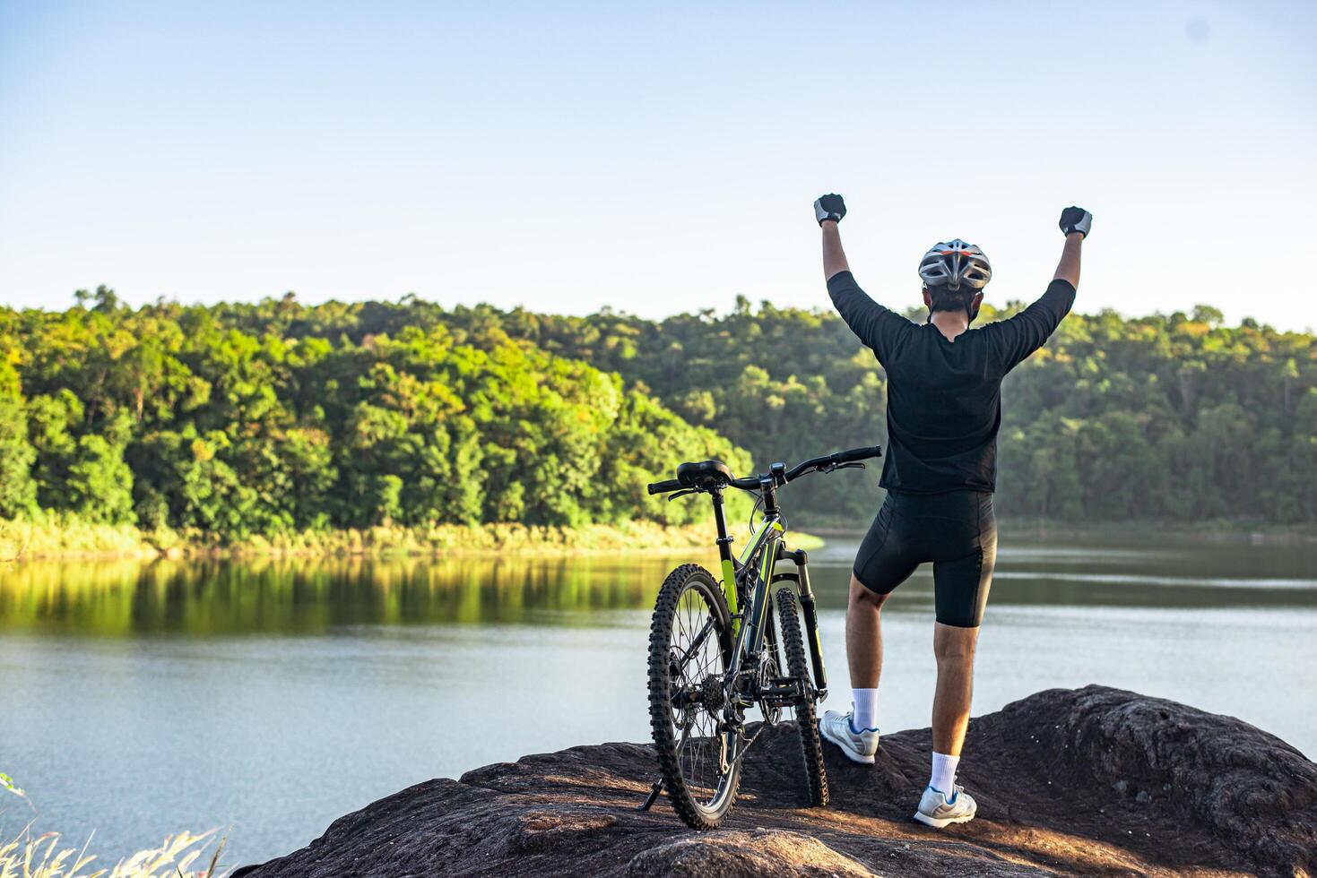 Mountain Bike cyclist standing on top of a mountain with bicycle .Extreme sport concept. photo