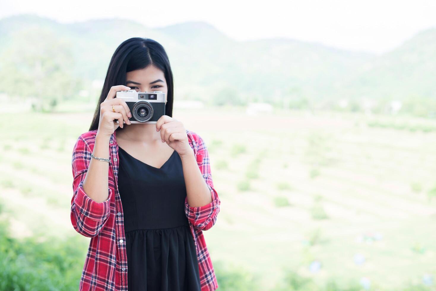 Young hipster woman photographer holding a vintage camera. photo