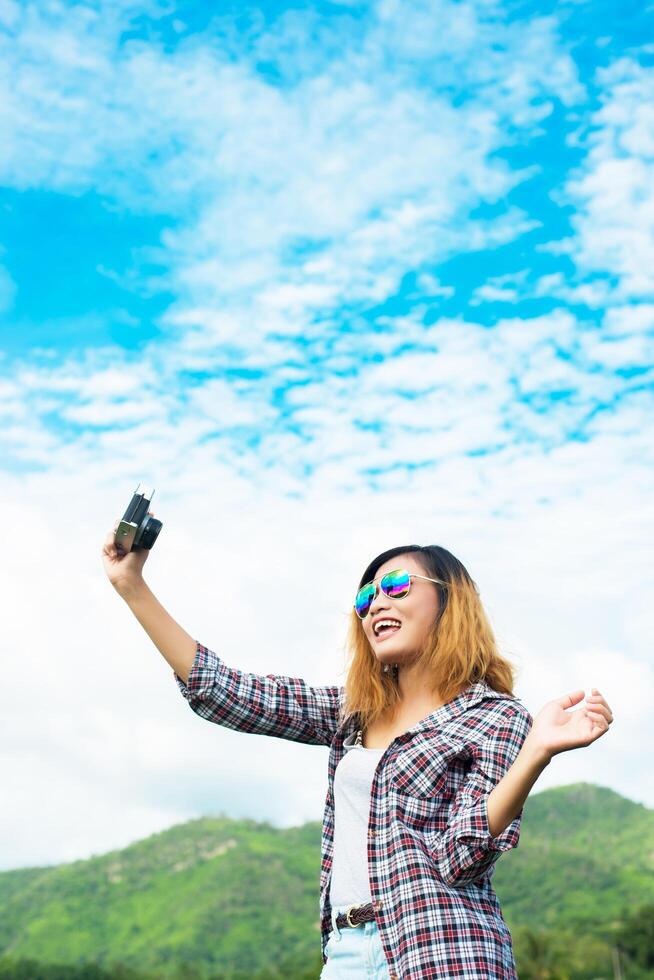 Young Hipster Woman with retro camera taking shot outdoor landscape ,Lifestyle mountain nature on background. photo