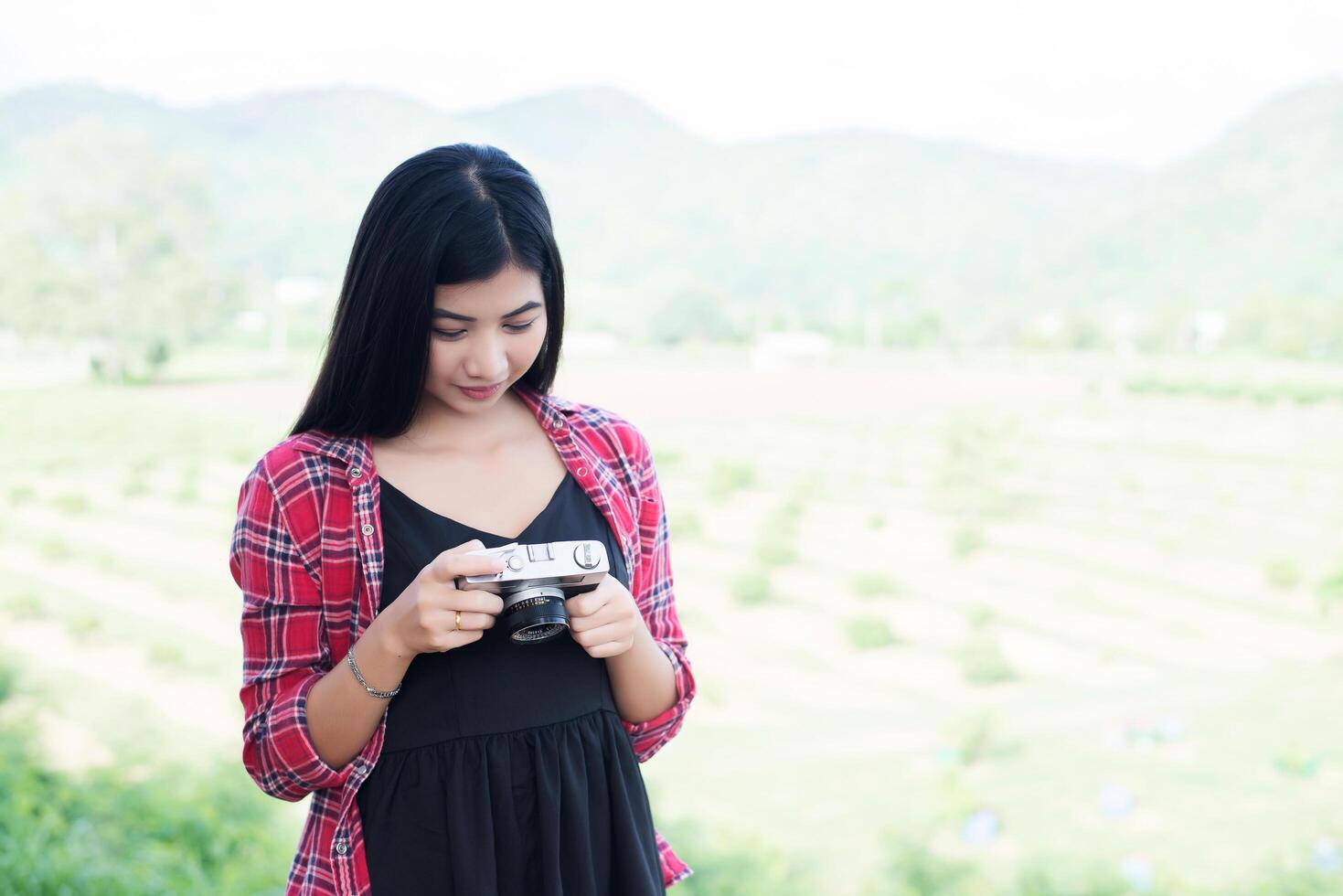 Young hipster woman photographer holding a vintage camera. photo