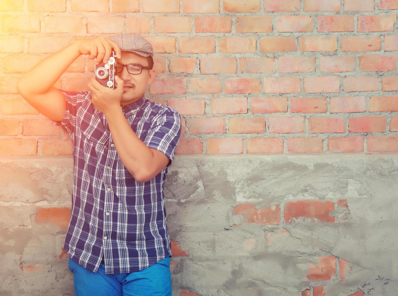 Hipster fashion handsome photographer man holding retro camera photo