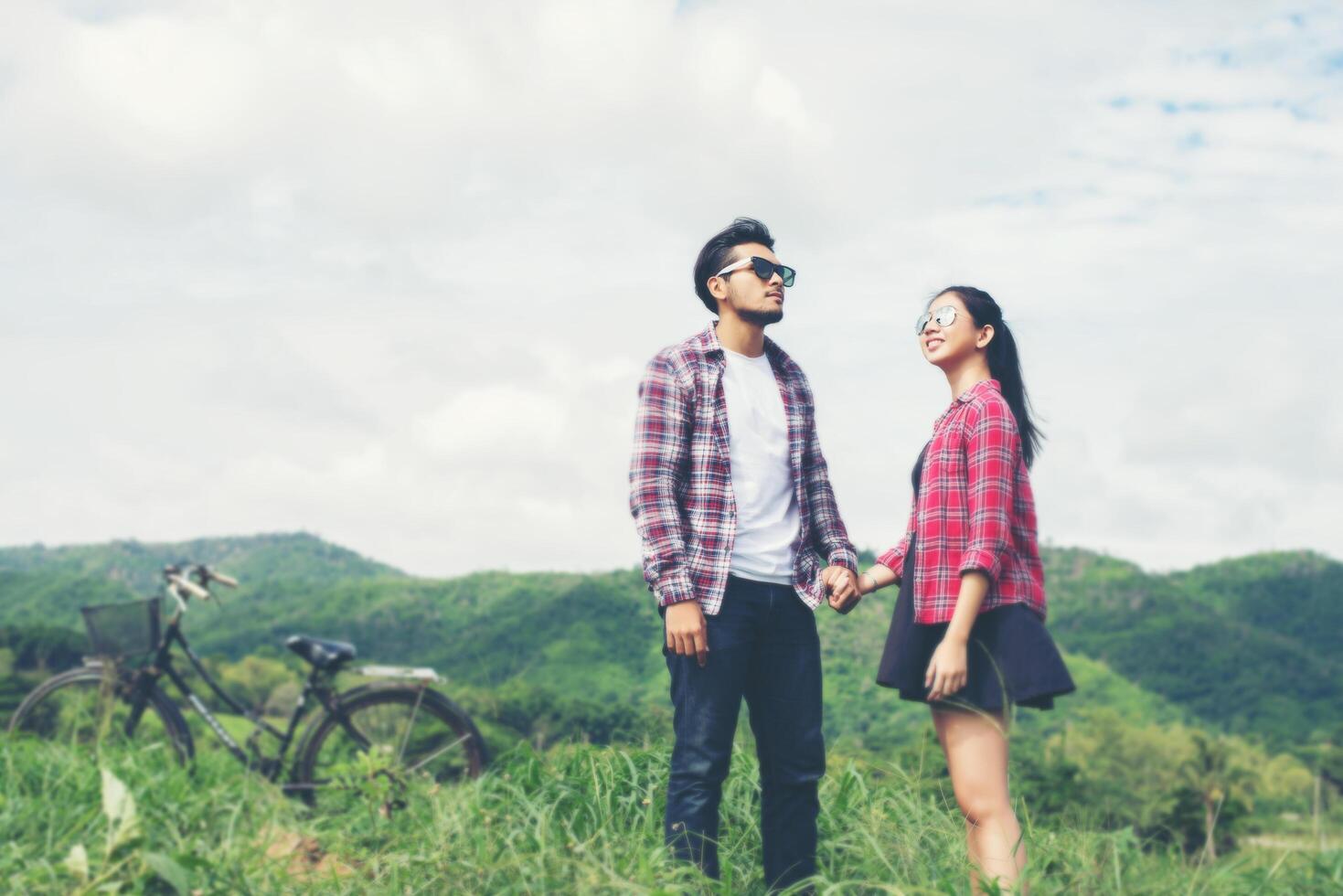 joven hipster pareja cogidos de la mano caminando por el prado ambiente relajante y natural es muy natural. foto