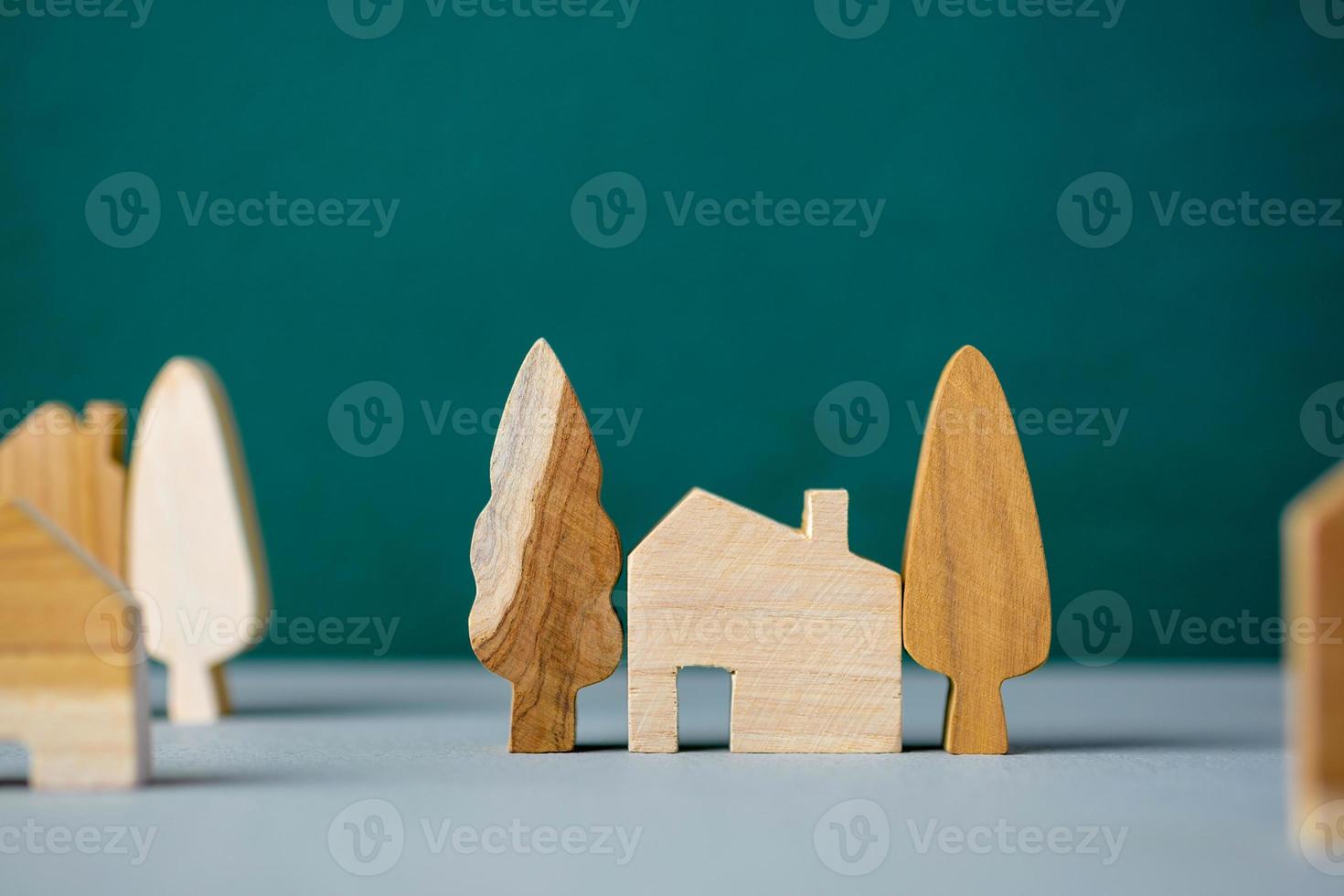 set of wooden house and tree decoration in village on grey floor and green background photo