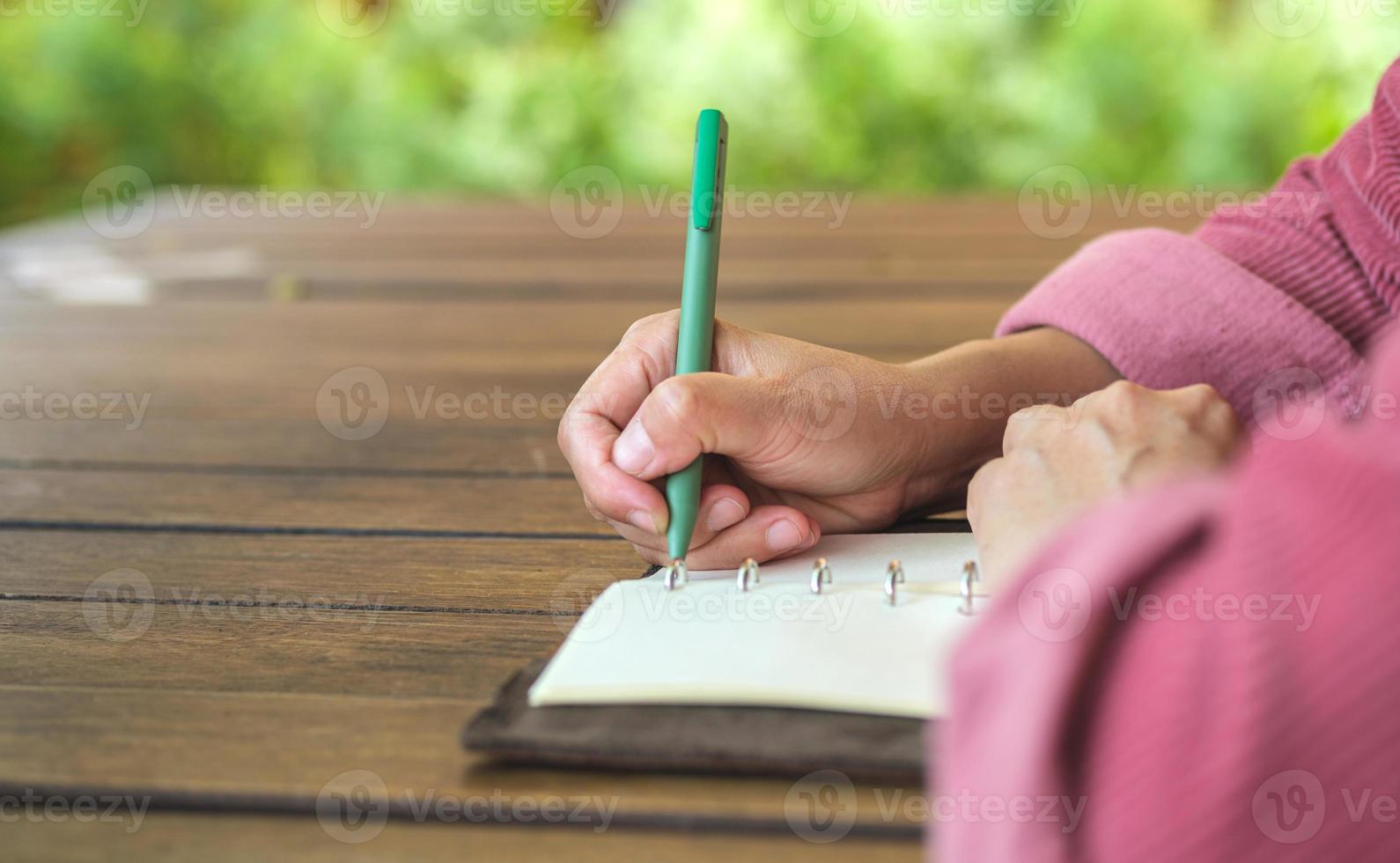 woman writing goal on notebook  at coffee shop outdoor space photo