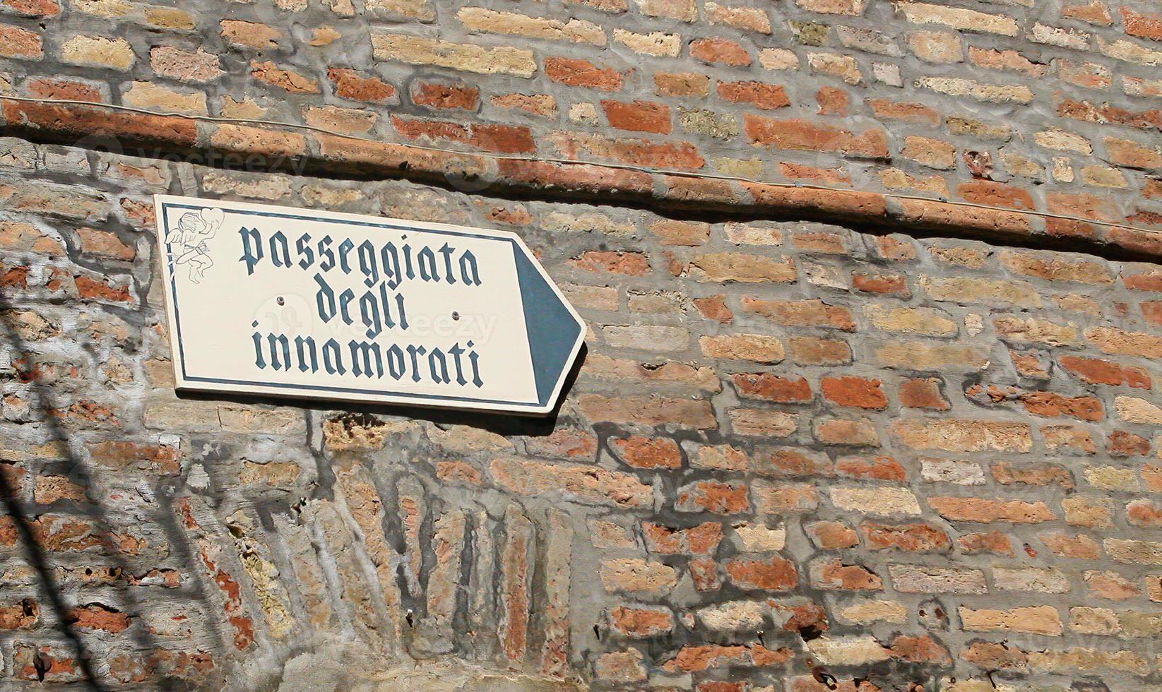 paseo de los enamorados, passeggiata degli innamorati, cartel de la calle con un pequeño cupido. castillo de gradara, italia foto