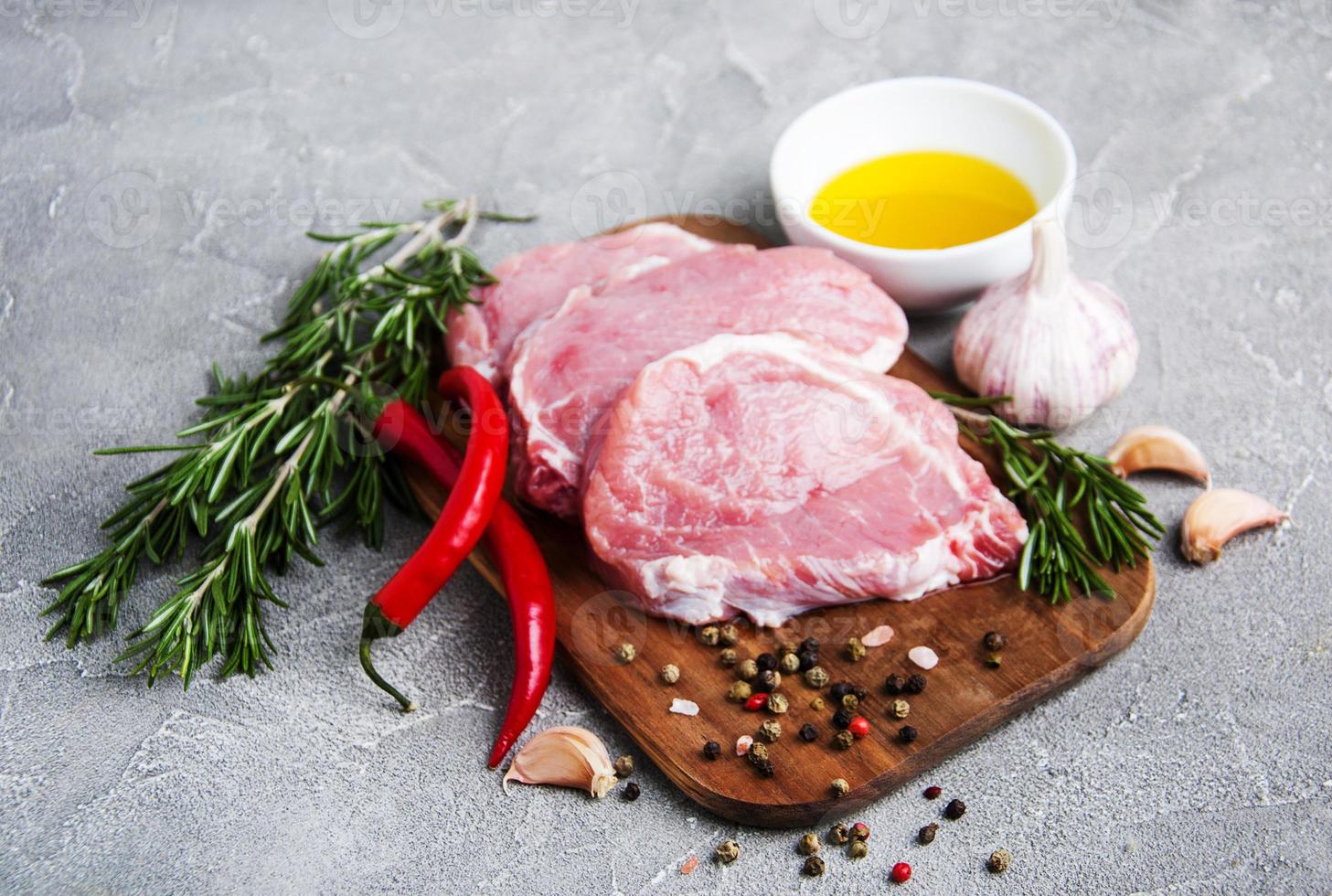 chuletas de cerdo crudas frescas con especias y hierbas foto