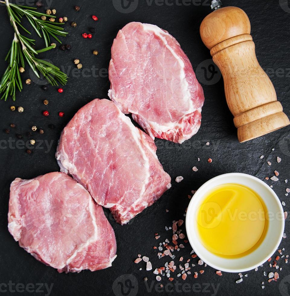 Fresh raw pork chops with spices and herbs photo