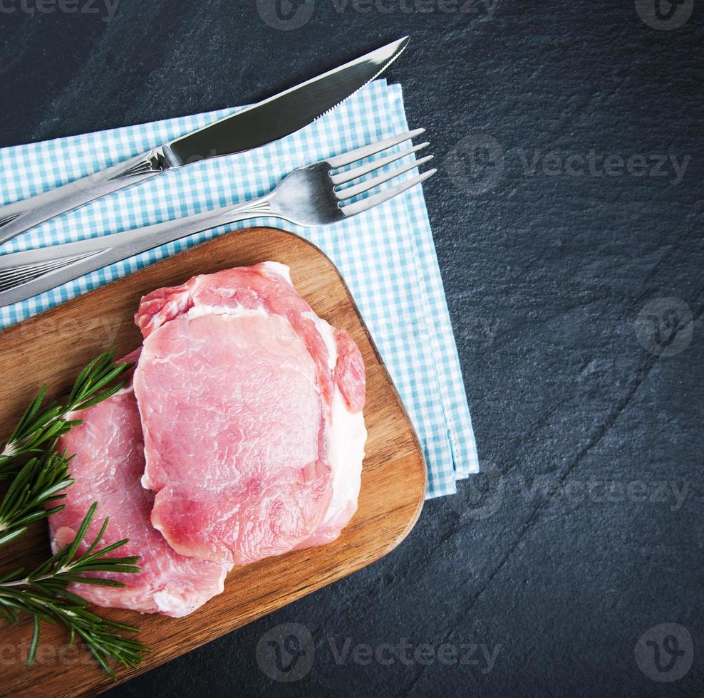 chuletas de cerdo crudas frescas con especias y hierbas foto