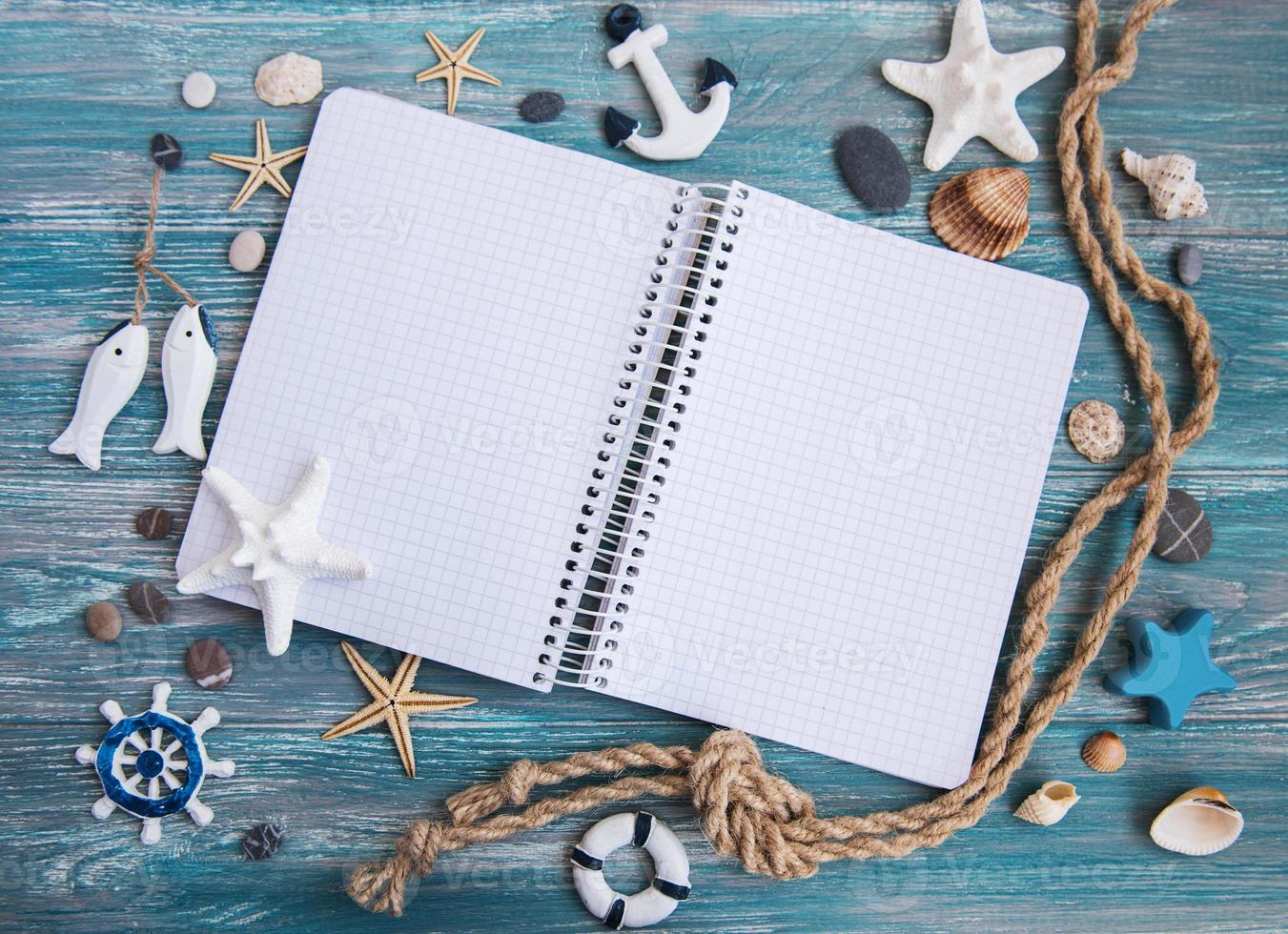 Shells and notepad on wooden table photo