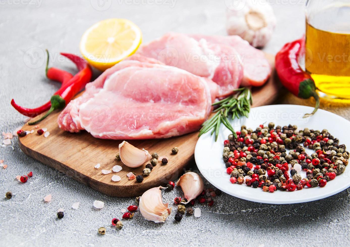 chuletas de cerdo crudas frescas con especias y hierbas foto