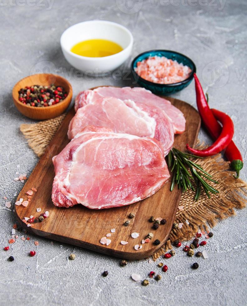 Fresh raw pork chops with spices and herbs photo
