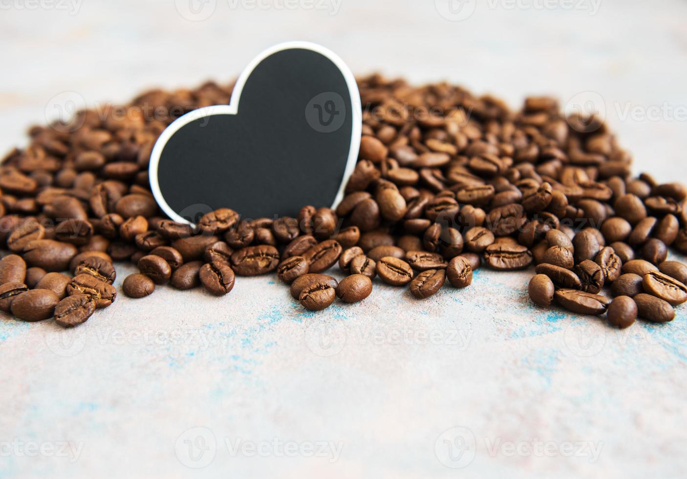 granos de café y tarjeta en forma de corazón foto
