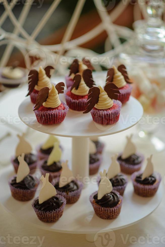 Close up of tray with lot delicious diversity pastry cakes tartlets and macaroon in a row. Fresh, multicoloured, colourful, green, yellow, white and pink sweet berry desserts, beautifully decorated photo