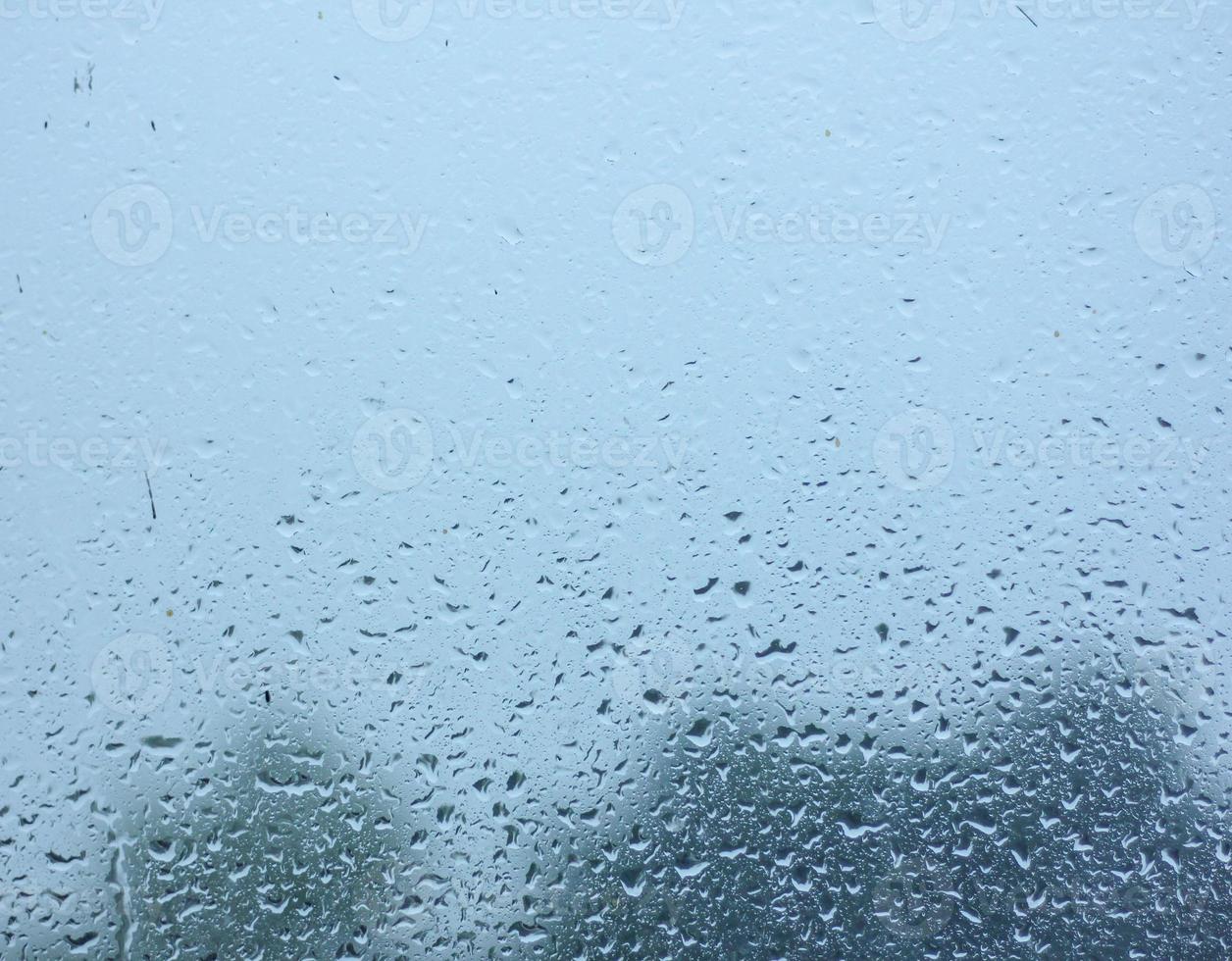 la lluvia cae agua sobre el cristal de la ventana foto