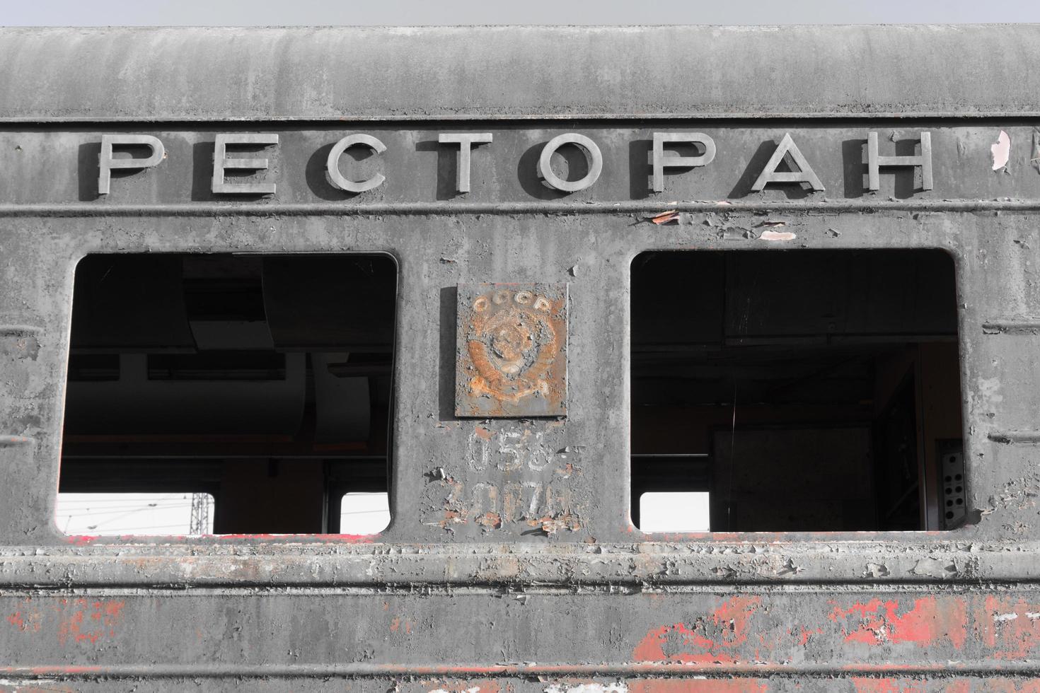 Close-up of the destroyed and rusty railway car with Soviet symbols and the inscription -restaurant photo