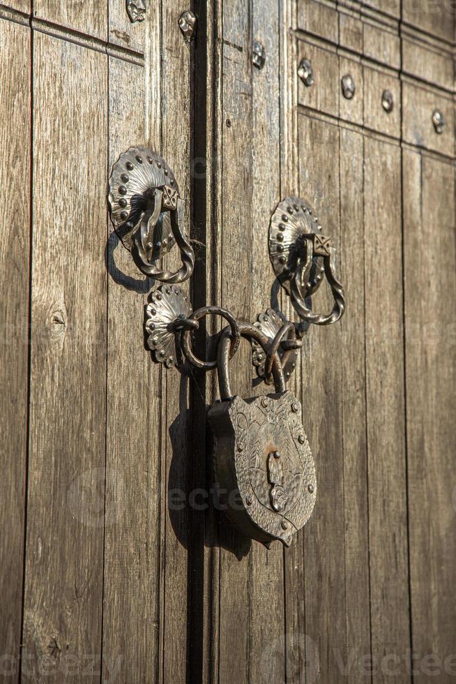 Massive iron lock on wooden gate. Old padlock on a wooden door. photo