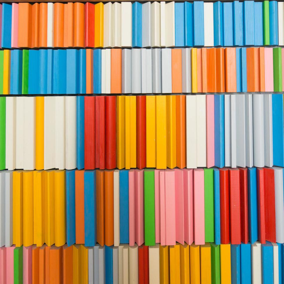 Tidy shelf with colorful books, green, red, blue, orange, pink, white, gray photo