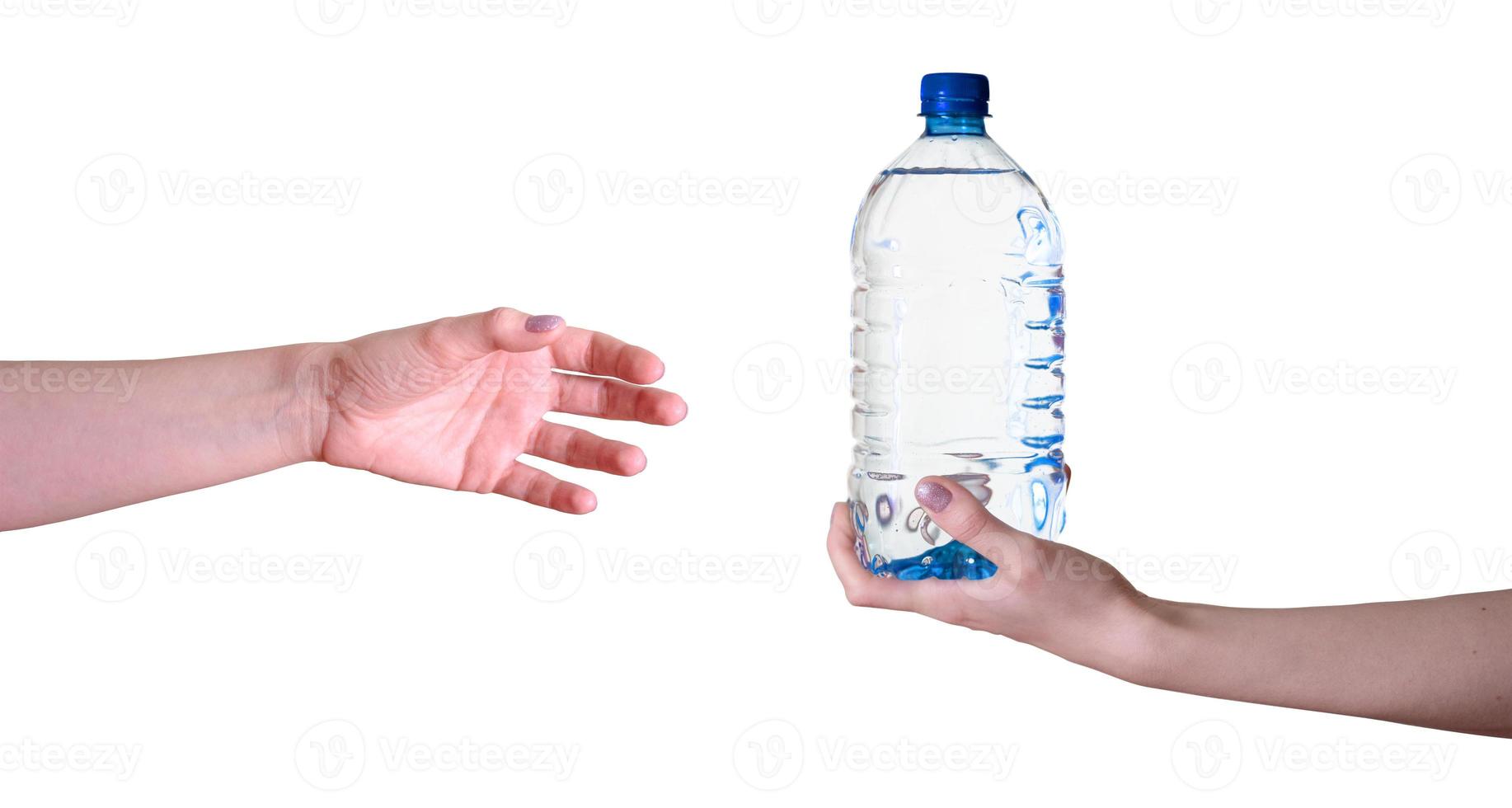 la mano de una mujer con una botella de agua pasa a la otra mano sobre un fondo blanco. foto