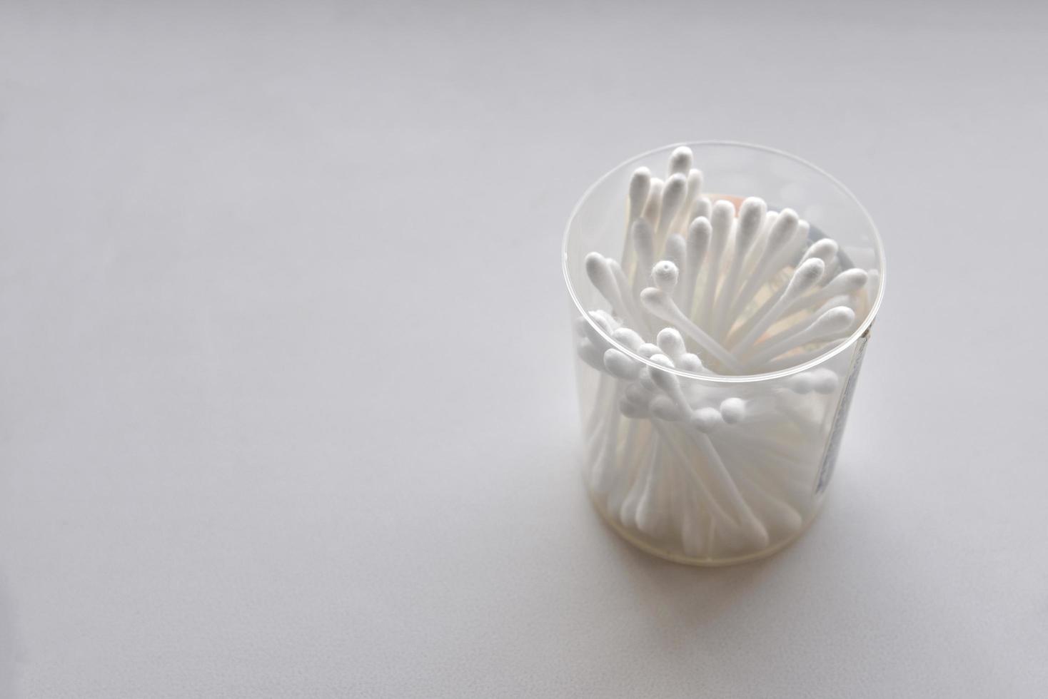 Cotton swabs in a jar on a white background photo