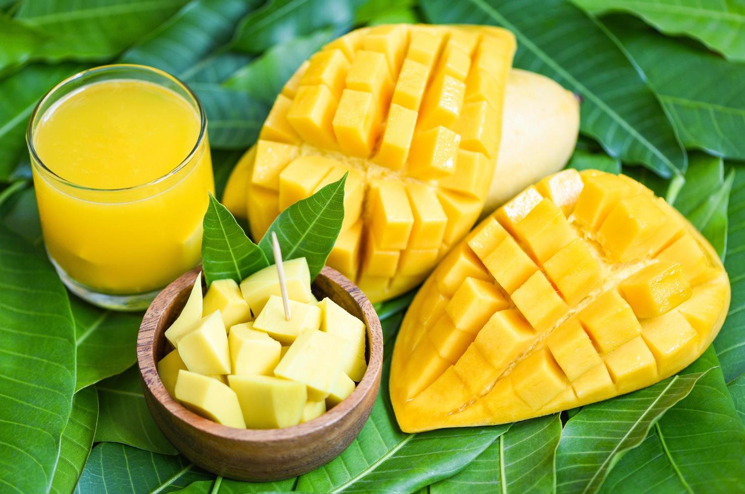 Mango juice glass with mango slice on mango leaves from tree tropical summer fruit concept - Sweet ripe mangos photo
