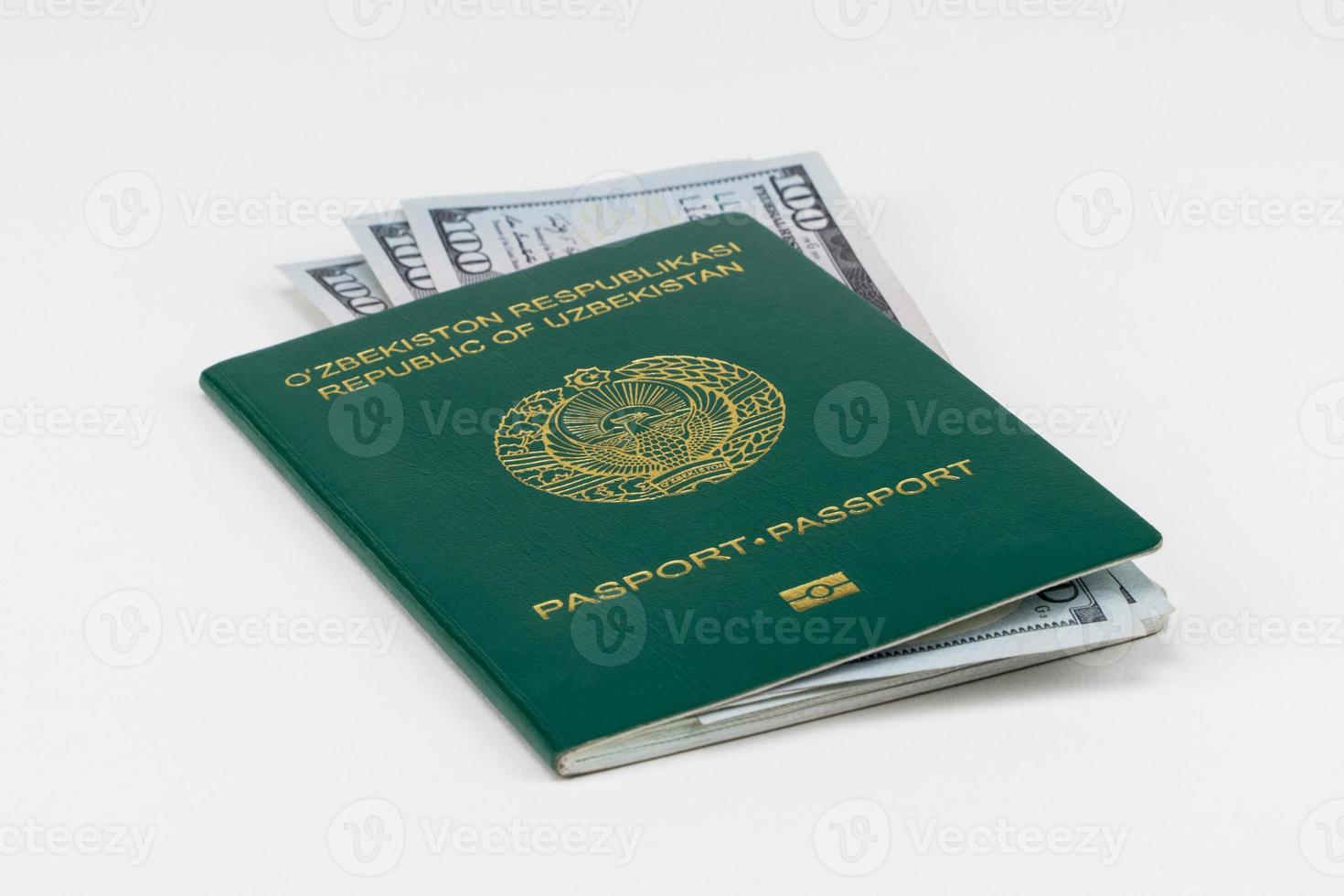 pasaporte de uzbekistán con dólares americanos sobre fondo blanco, aislado foto