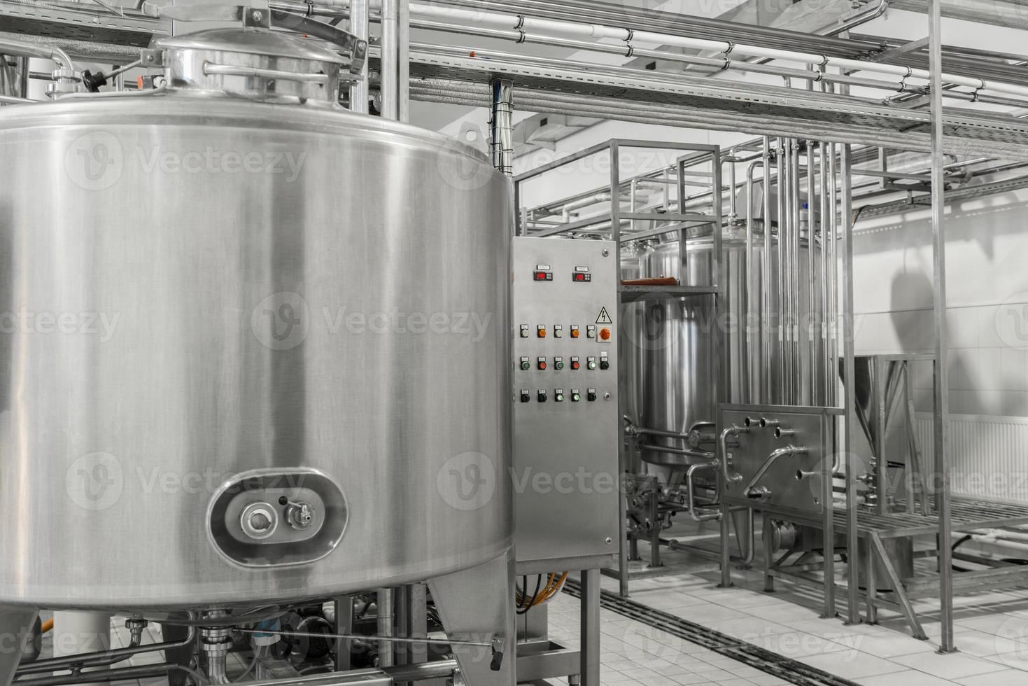 panel de control electrónico y tanque en una fábrica de leche. equipo en la planta de productos lácteos foto