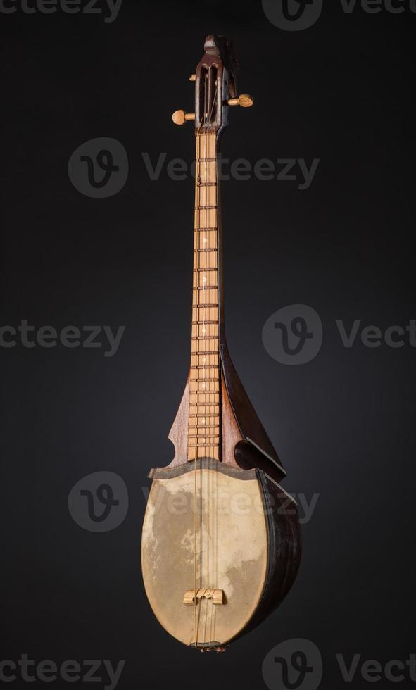 ancient Asian stringed musical instrument on black background with backlight photo