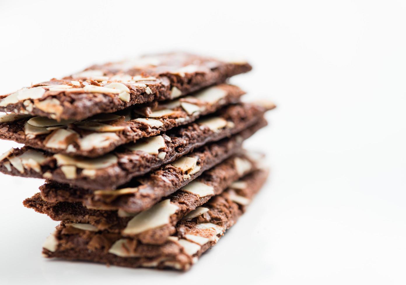 galleta de brownie con toboganes de almendras sobre fondo blanco foto