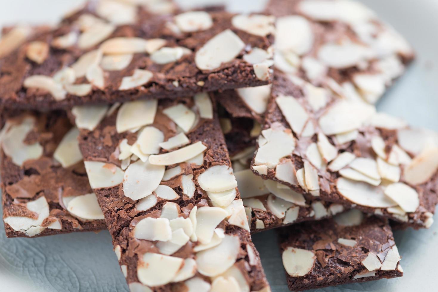 galleta de brownie con toboganes de almendras sobre fondo blanco foto