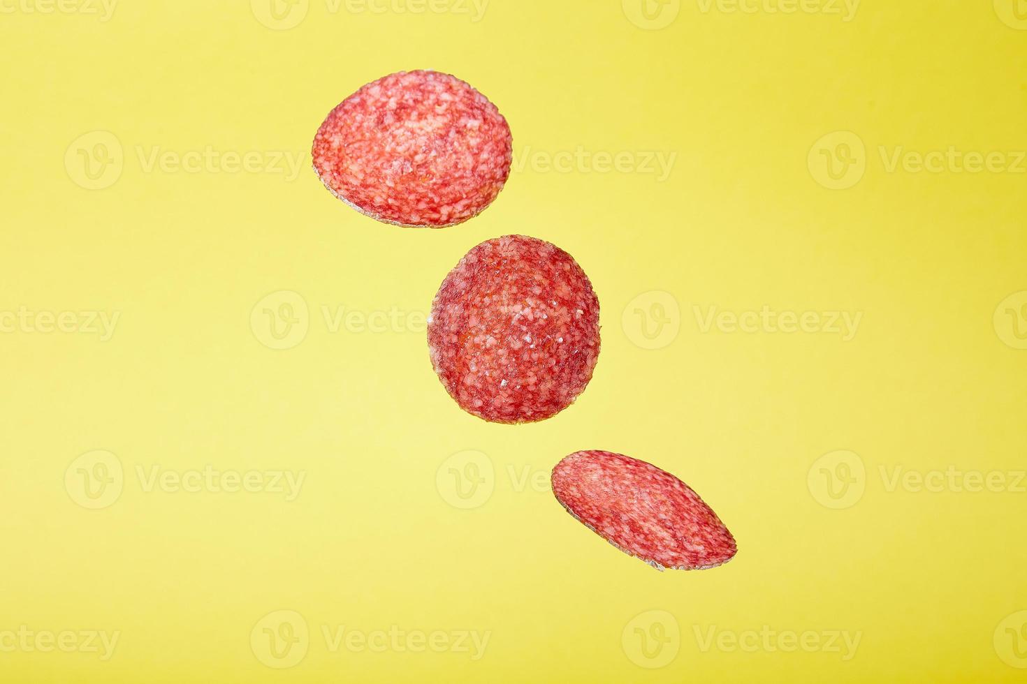 Abstract Flying Salami on Yellow Background Food Concept photo